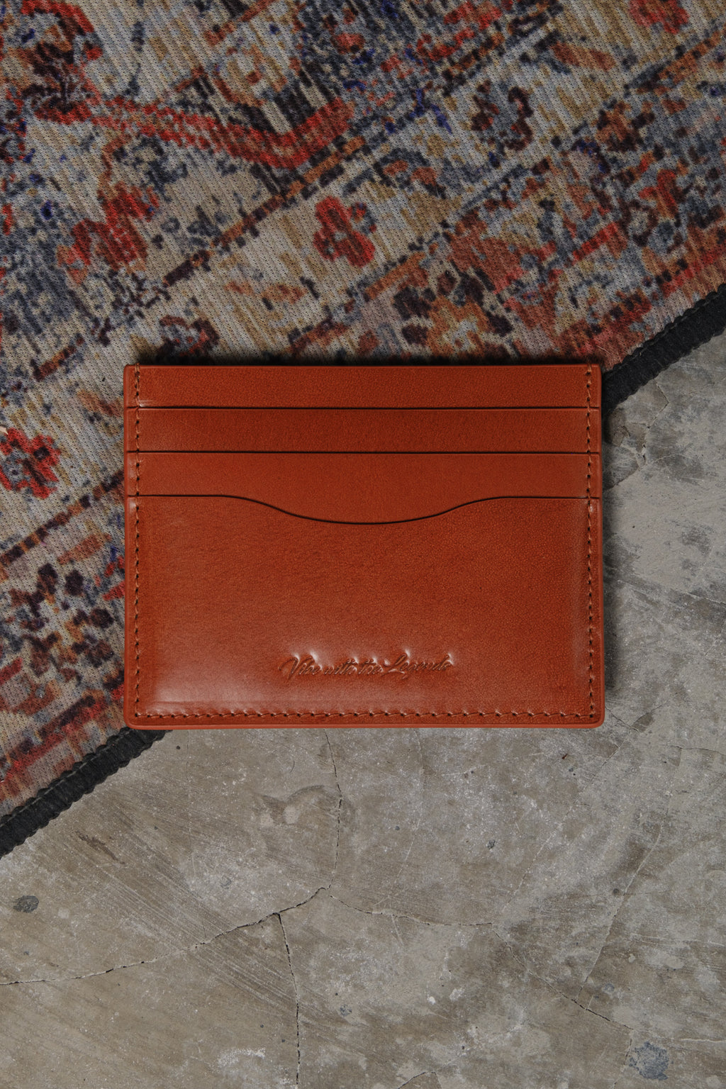 Brown leather cardholder on a textured surface
