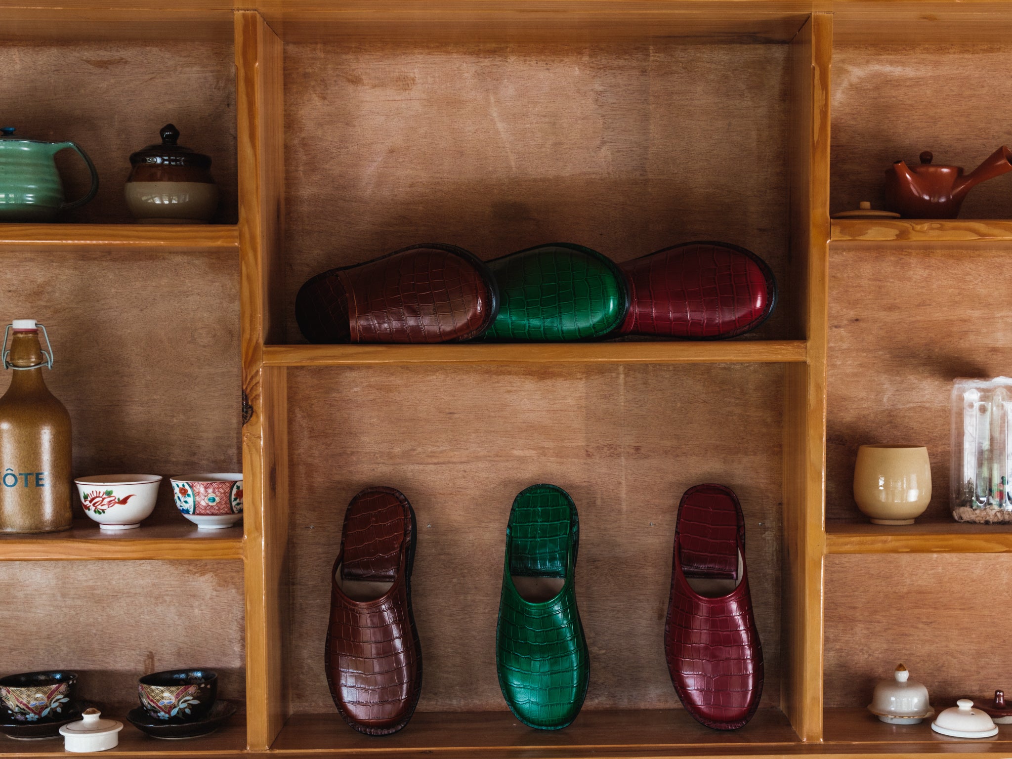 Wooden shelves with various items including shoes and ceramicware.